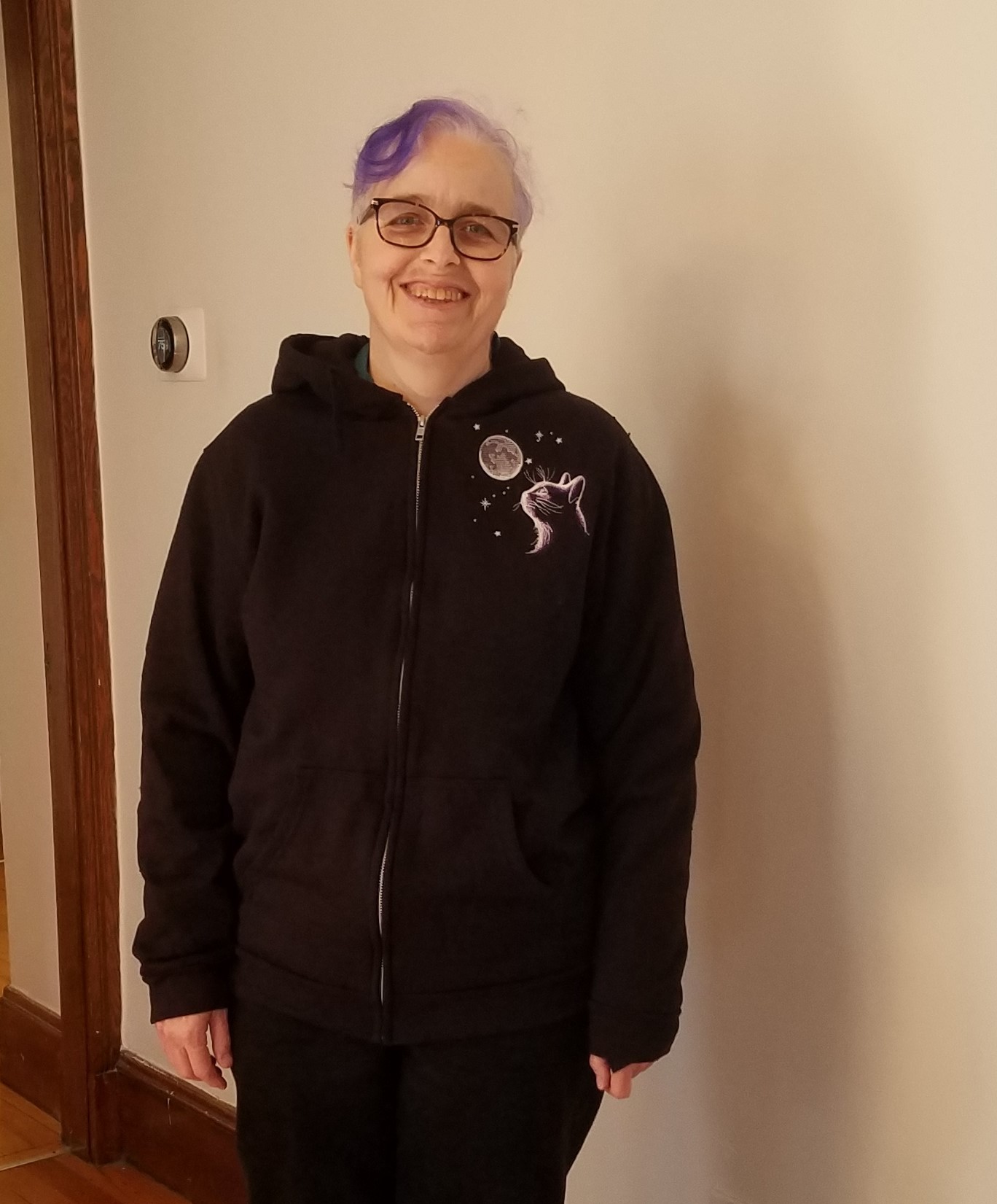 me wearing a black jacket with embroidered cat